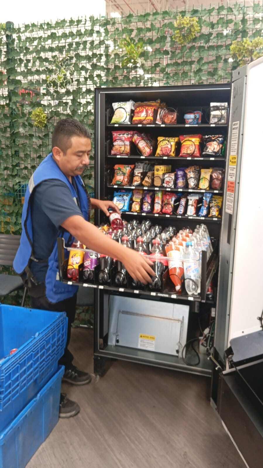 Professional engineer servicing a modern workplace vending machine for a UK business
