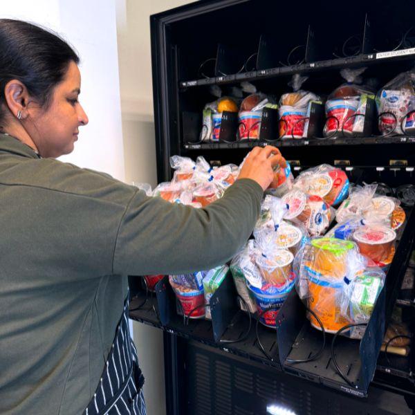 Healthy vending machine stocked with protein bars, nuts, popcorn and nutritious snacks in a modern workplace.