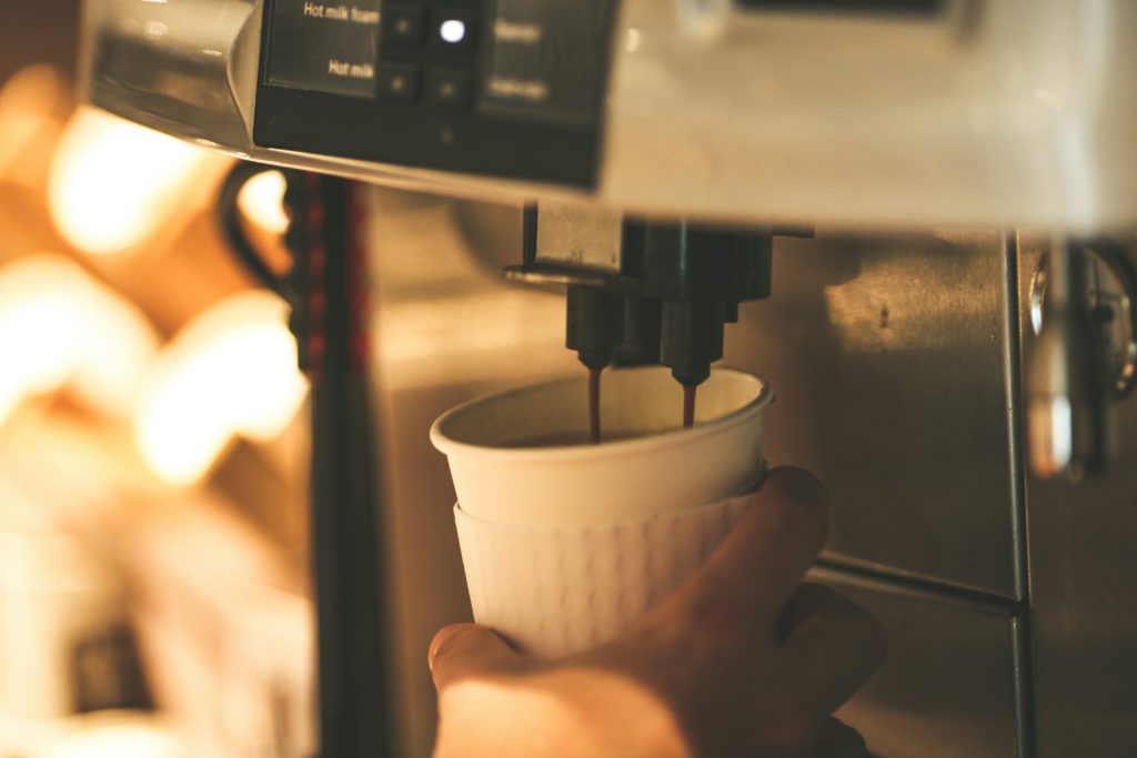 Bean-to-cup coffee machine in a stylish hotel reception lounge serving fresh coffee to guests.